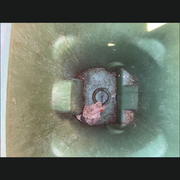 Green recycling bin interior before cleaning, with staining, residue, and leftover trash in the base